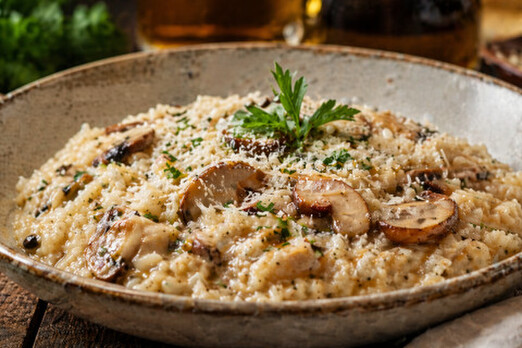 Cremiges Risotto mit Pilzen und Parmesan frisch zubereitet in einer Schüssel